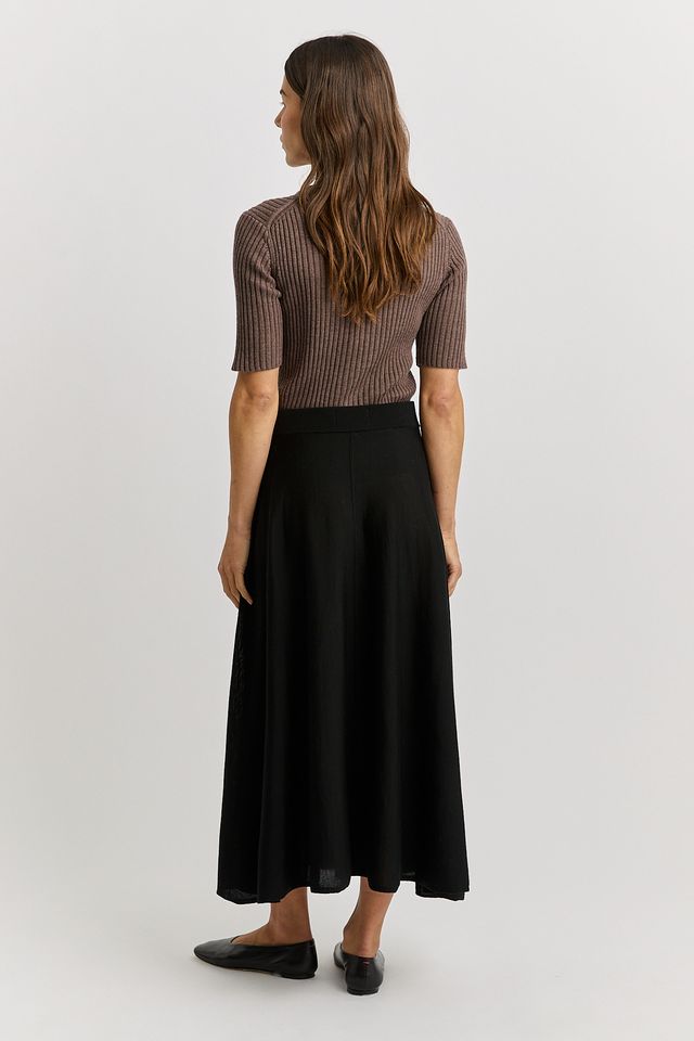 Woman wearing the Merino wool A-Line Knit Skirt in black by toorallie