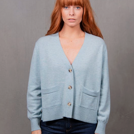 Woman wearing the Vee Neck Cropped Cardigan in Aquamarine blue by Bridge and Lord