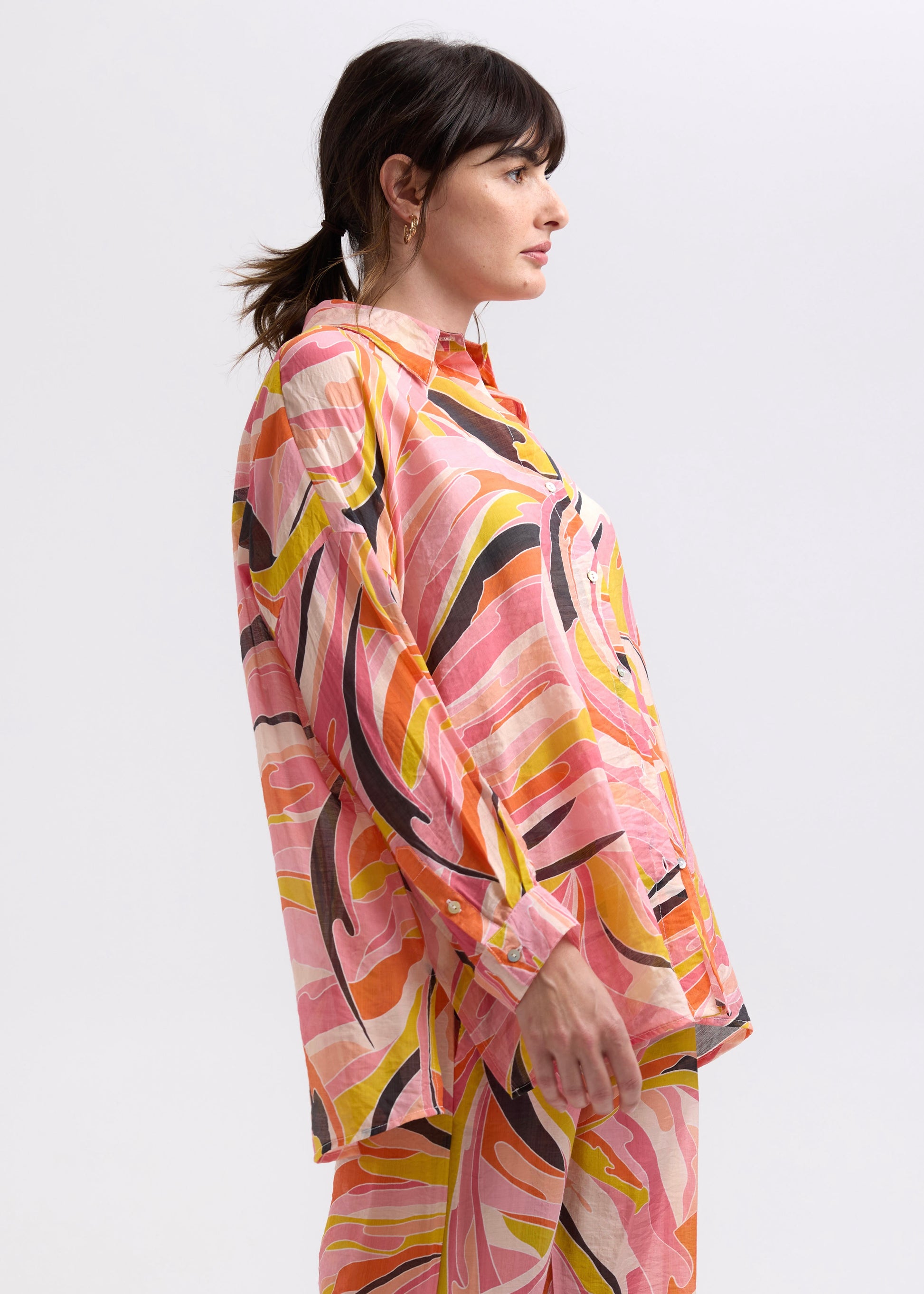 Woman wearing the Summer Shirt with matching set Summer Pants by Zaket and Plover in Sunset orange