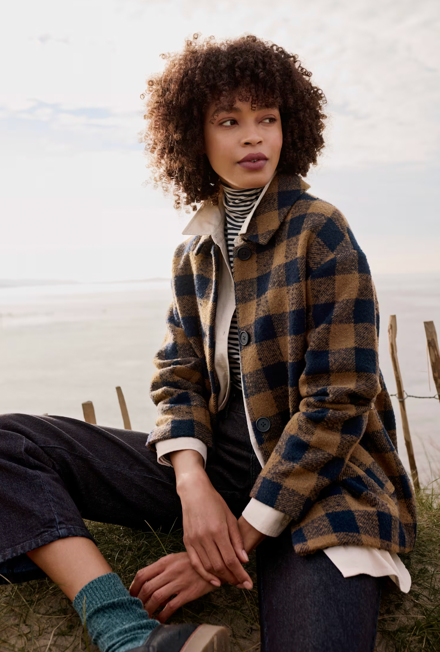 SEASALT's Beamwind Coat in Harbour Maritime, model wearing jacket by beach