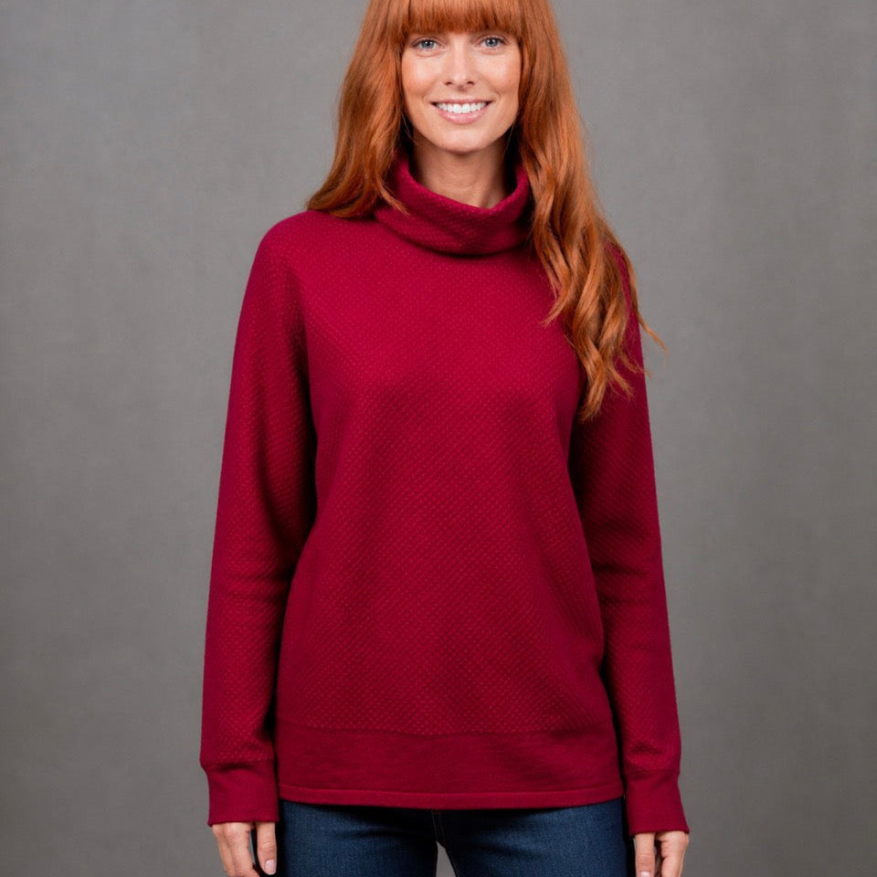 Woman wearing the Ball Stitch high Crew red jumper in Cassis by Bridge and Lord