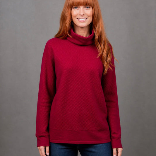 Woman wearing the Ball Stitch high Crew red jumper in Cassis by Bridge and Lord