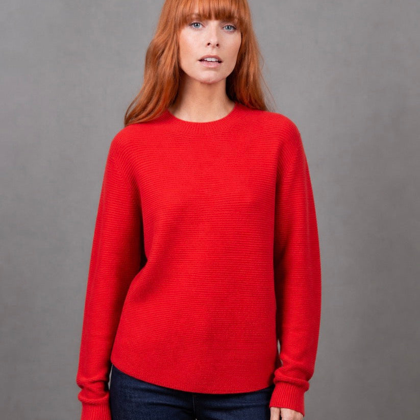 Woman wearing the Bridge and Lord Dolman sleeve red jumper in Cayenne