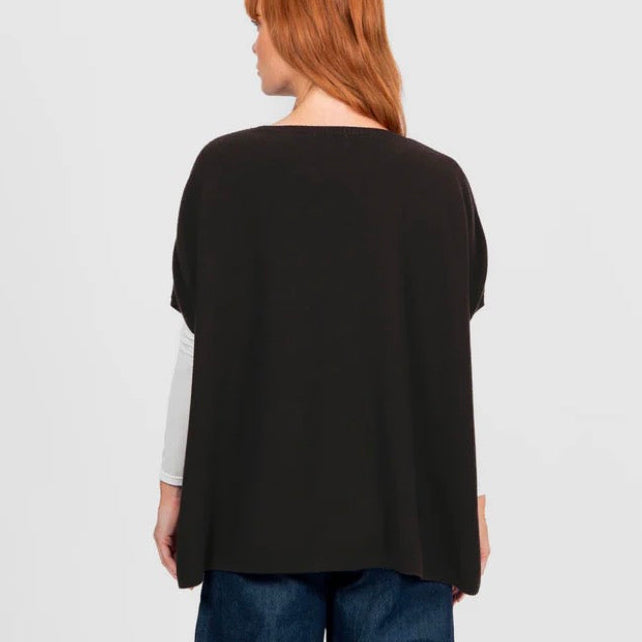 Woman wearing the Bridge and Lord seed stitch black poncho