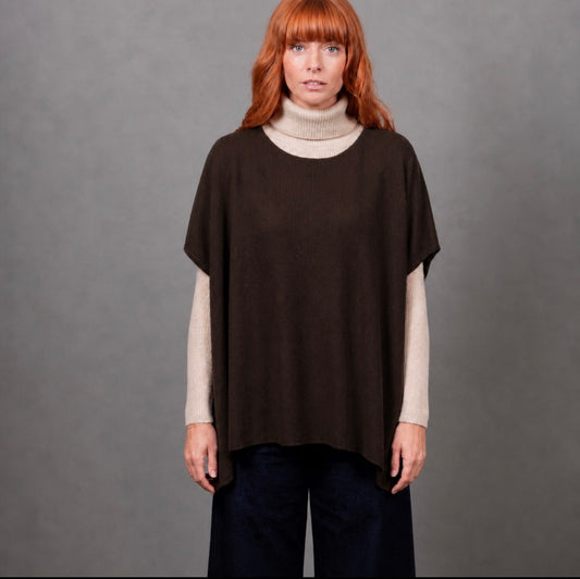 Woman wearing the Seed Stitch brown poncho by Bridge and Lord