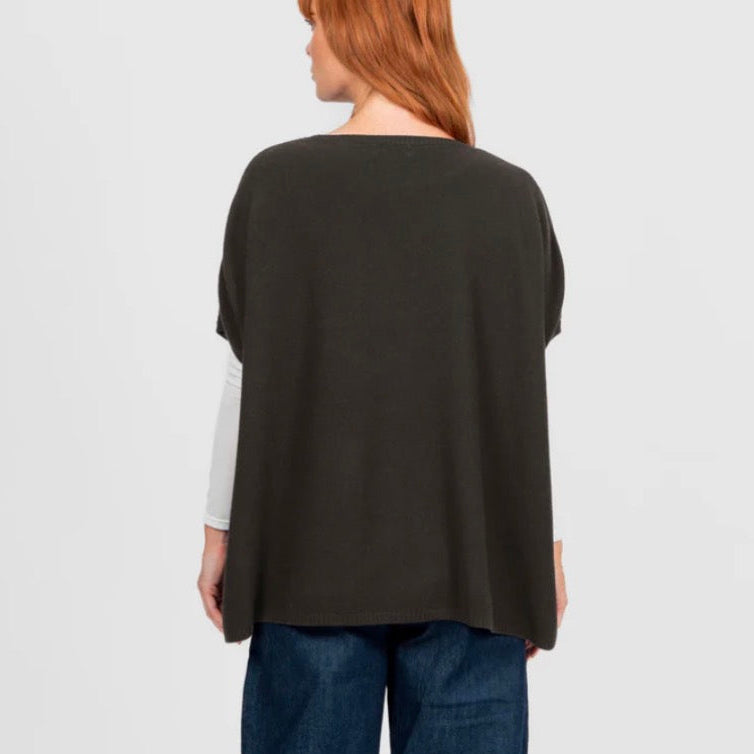 Woman wearing the Seed Stitch brown poncho by Bridge and Lord
