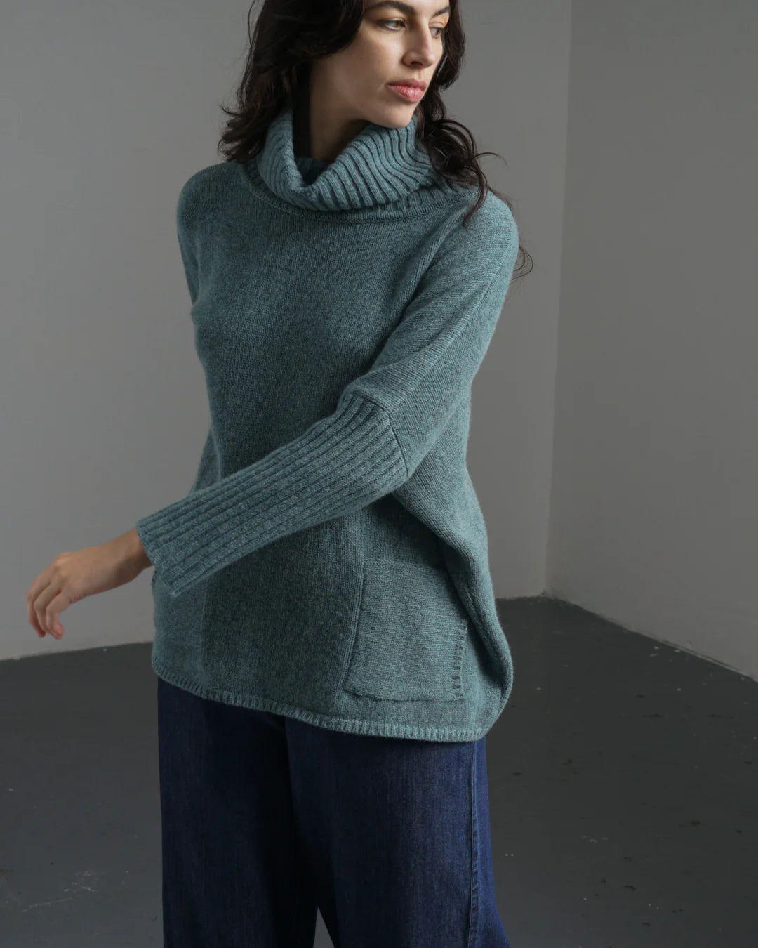 Woman wearing the Bibico Adela turtleneck woollen Jumper in Caspian with pockets