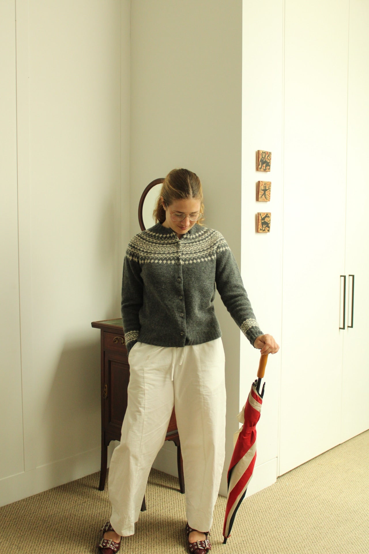 Woman wearing the Harley of Scotland Women's Fairisle Cardigan in Grey and white