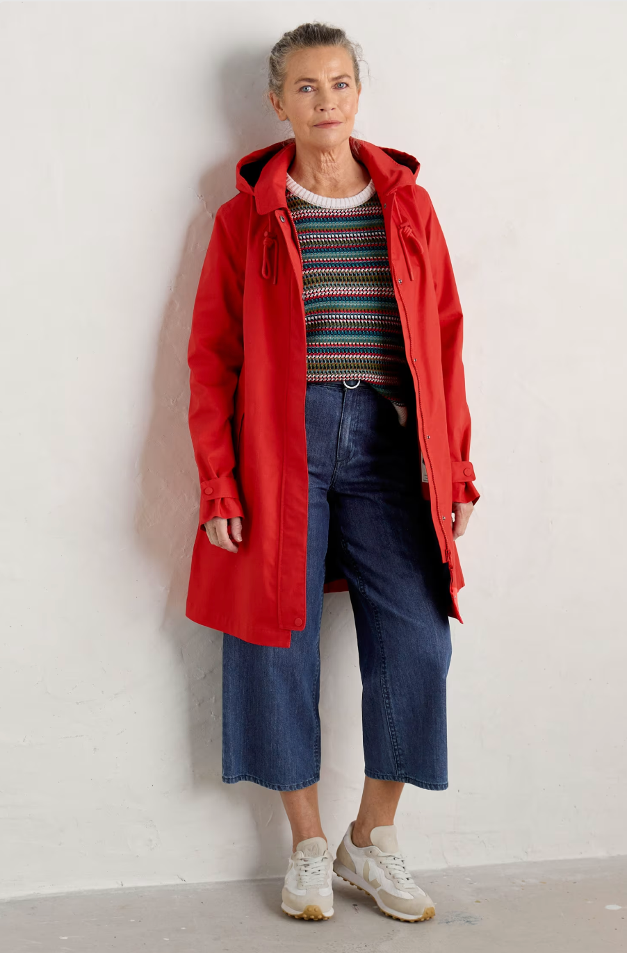 SEASALT's Cloudburst Mac in Tomato, styled over jeans and jumper