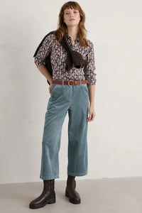 SEASALT's Larissa Shirt in Floral Stamp Maritime, full outfit with blue pants, belt, boots and brown jumper