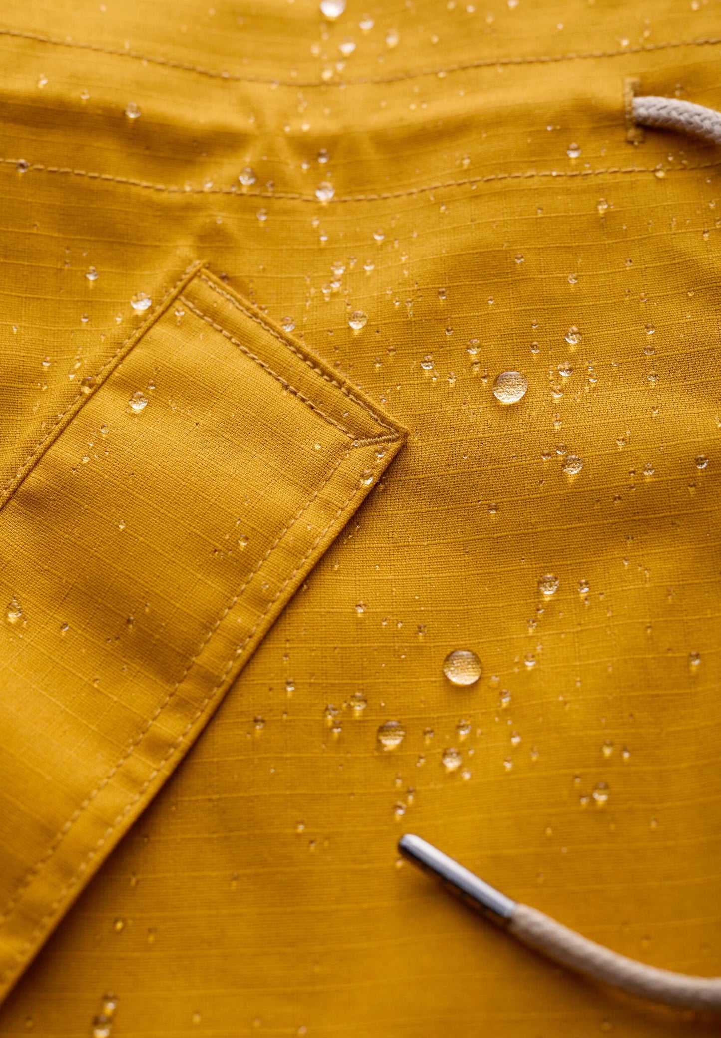 Rain proof coat from Seasalt in yellow.