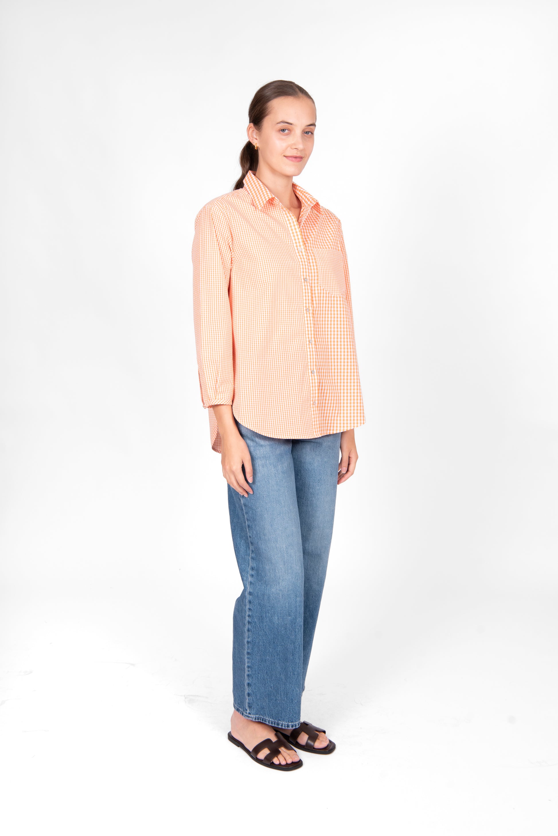 Woman wearing the Bridge and Lord Gingham cotton shirt in Clementine orange