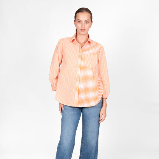Woman wearing the Bridge and Lord Gingham cotton shirt in Clementine orange