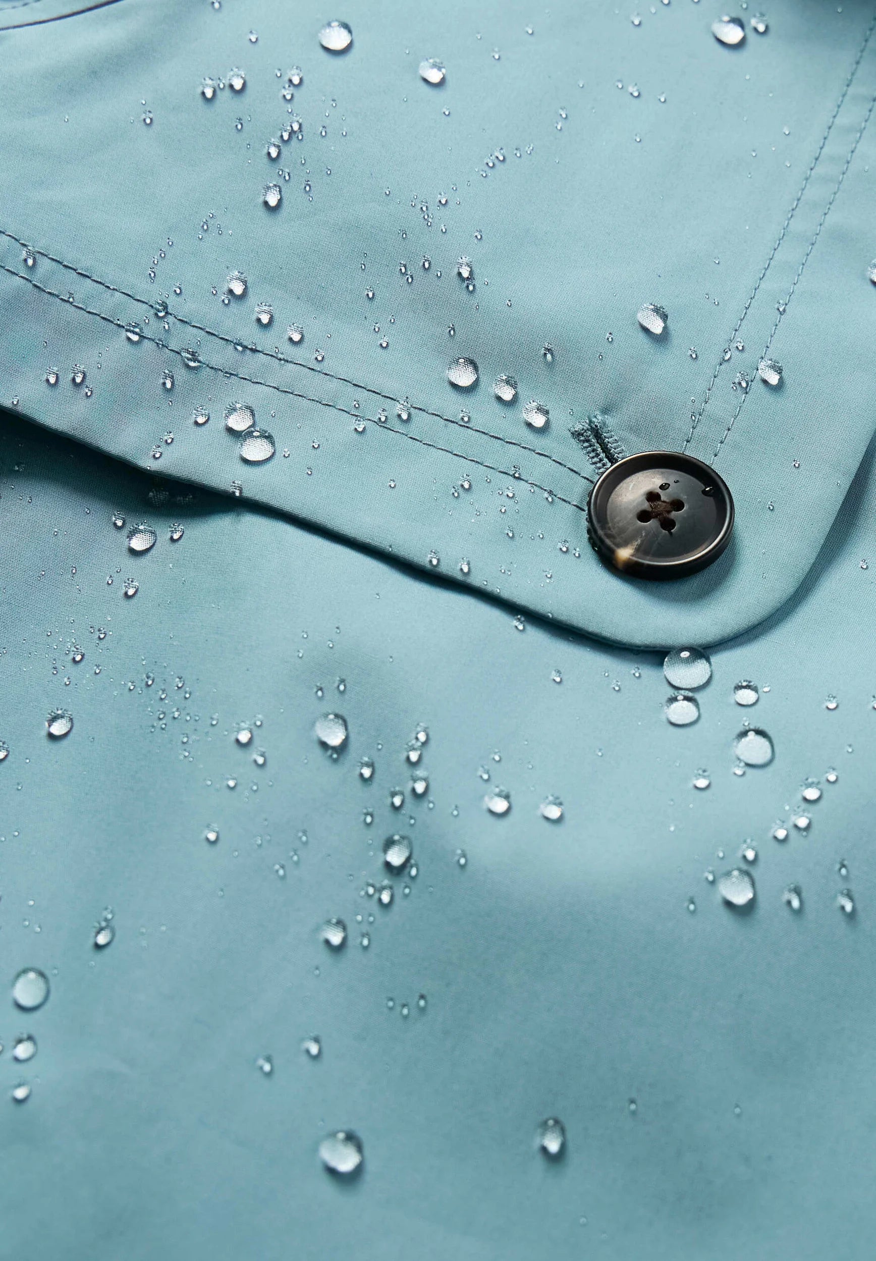 Close up of rainproof material of the Penweathers Trench Coat in Hail blue by SEASALT