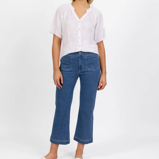 woman wearing the daily jean by vassalli- straight leg ankle grazer jean with front pockets in blue hue